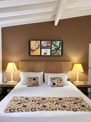 A hotel room with a bed, two bedside lamps, a headboard, and a wall with three framed pictures. - Hotel Aromax del Campestre (Medellín)