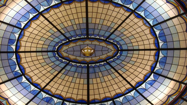 Een glas-in-lood plafond met een centraal embleem.