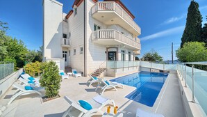 Un edificio con piscina, sillones de descanso y zona de recepción.