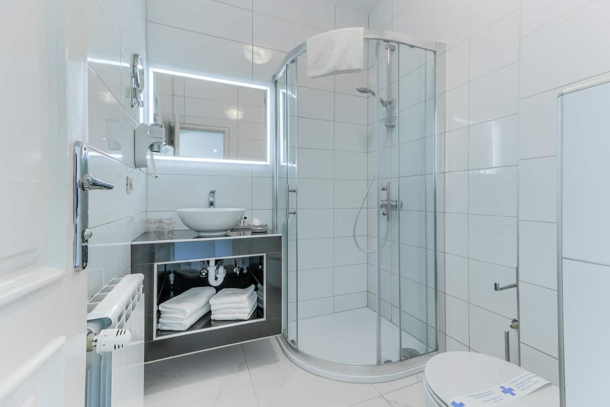standard double room | bathroom | shower, rainfall showerhead, hair dryer, slippers