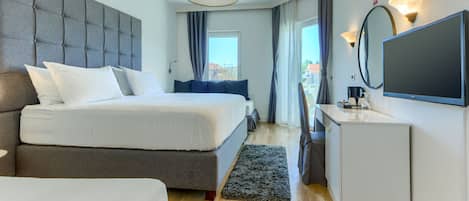 Una habitación de hotel moderna con una cama grande, una mesita de noche, un televisor de pantalla plana y vistas a la ciudad desde la ventana.
