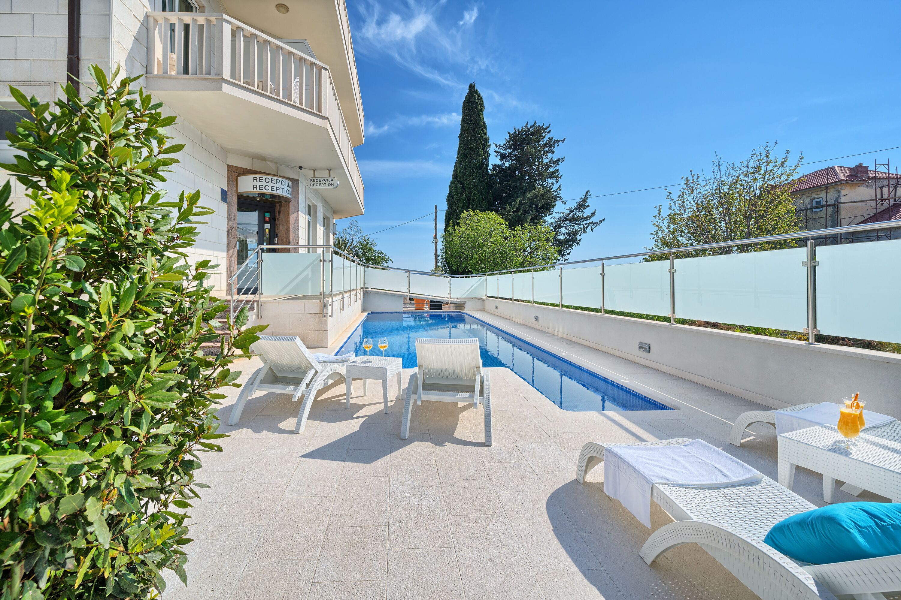 A pool area with lounge chairs and a reception desk.