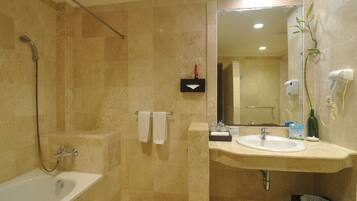 Une salle de bain avec une baignoire, un lavabo, un miroir et une douche.