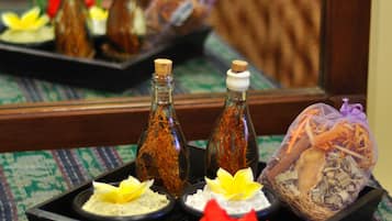 A tray with various items including bottles, a flower, and a decorative object on a patterned tablecloth.