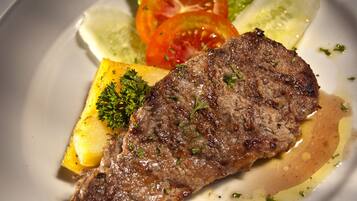 A plate with a grilled steak, lemon slices, and a garnish of parsley.