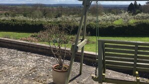 Un jardin agrémenté d’une pergola en bois, d’une plante en pot et d’un chemin pavé de pierres.