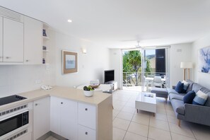 Apartamento Deluxe, 2 habitaciones | Zona de estar | Televisión de pantalla plana de 50 pulgadas con canales por satélite
