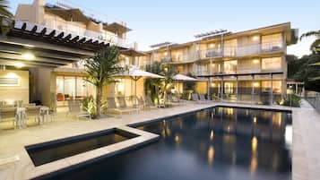 Una piscina al aire libre, sombrillas, tumbonas