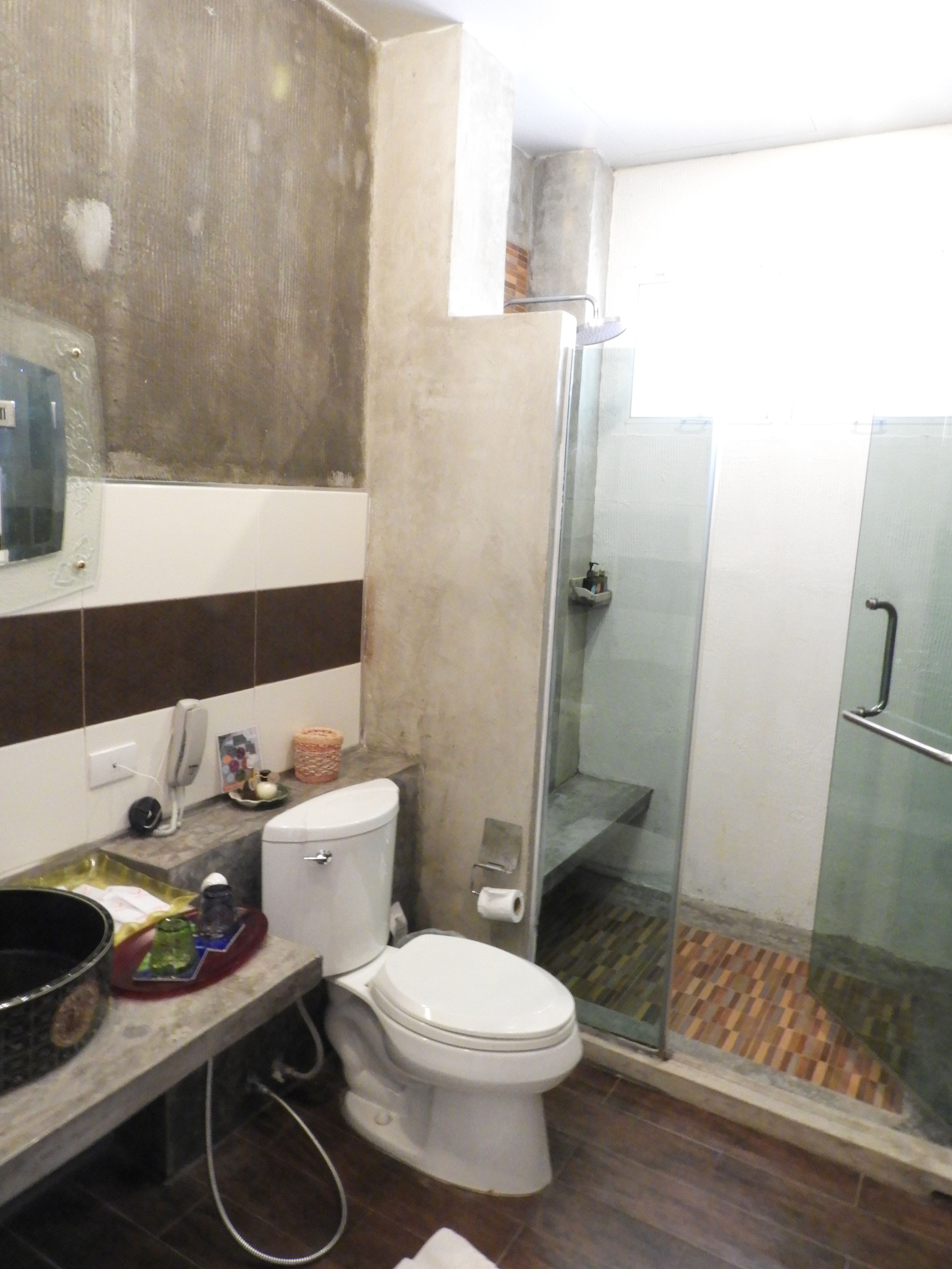A bathroom with a toilet, a shower, and a sink.
