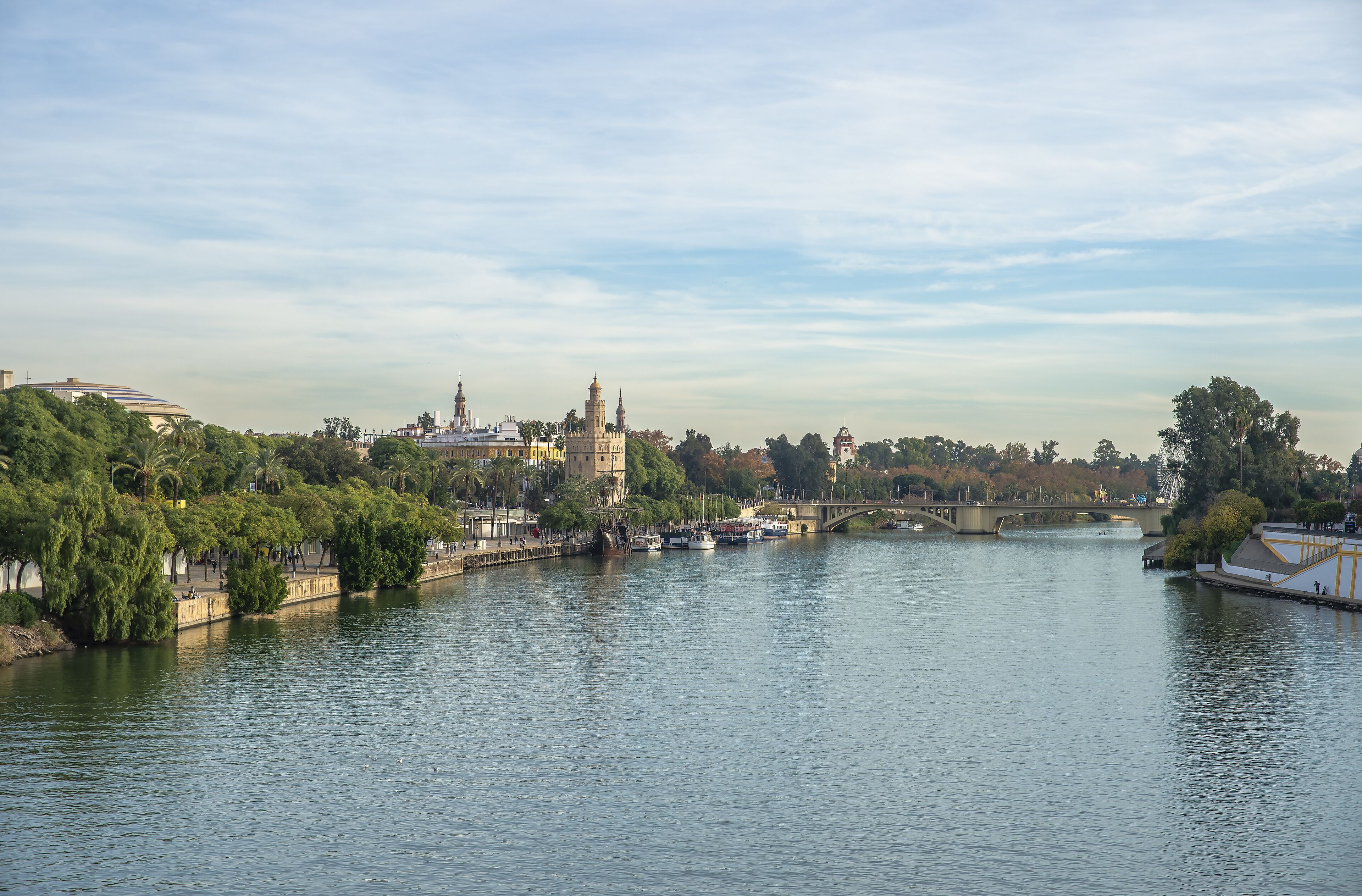 A river with boats, a bridge, and buildings along the banks.