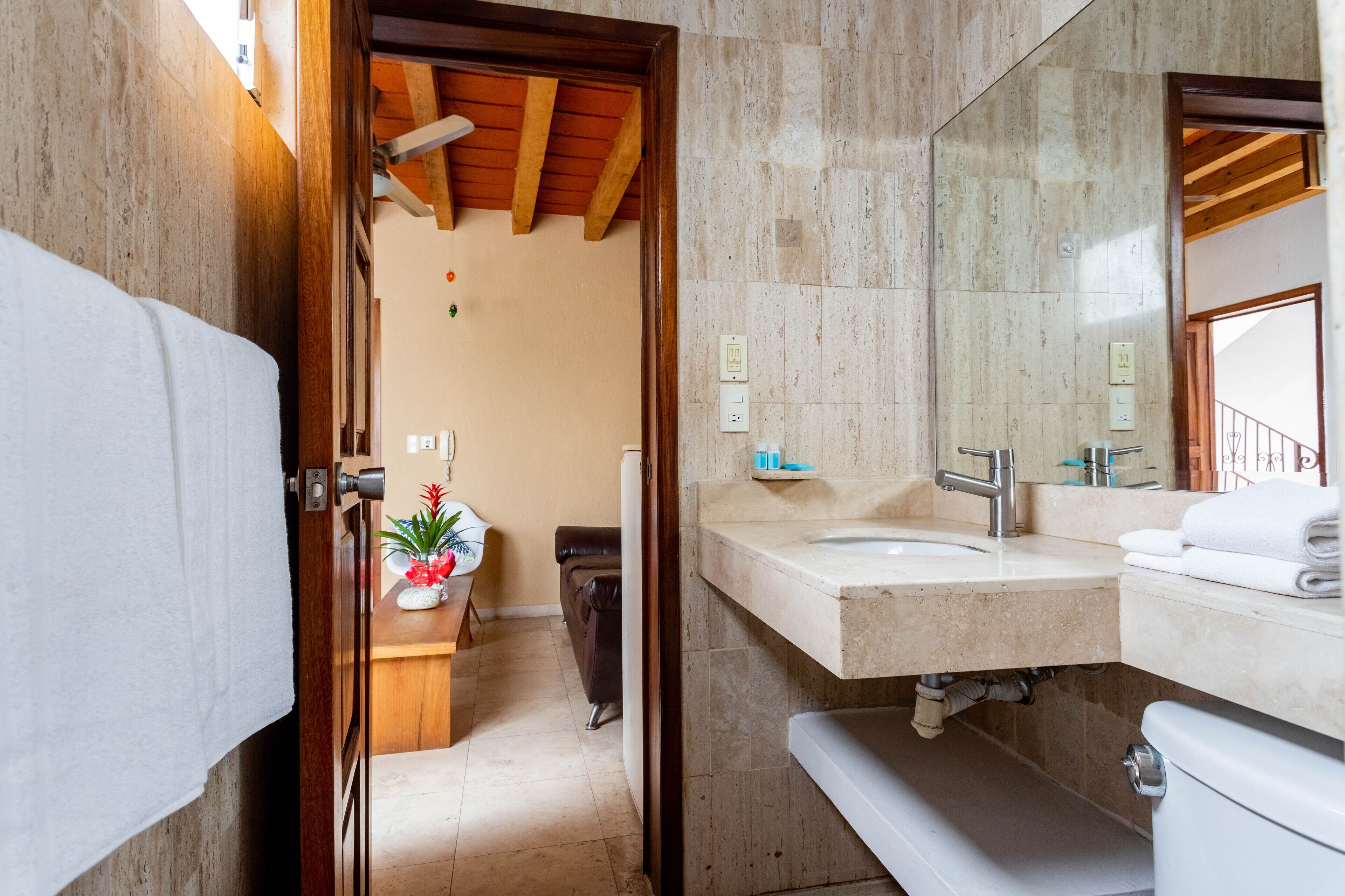 Ein Badezimmer mit Holzboden, Waschbecken, Toilette und Spiegel.