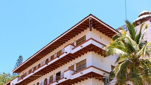 A multi-story building with a sign reading "michel" on the ground floor. - Olas Altas Suites (Puerto Vallarta)