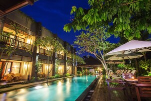 Una piscina al aire libre, sombrillas, sillones reclinables de piscina