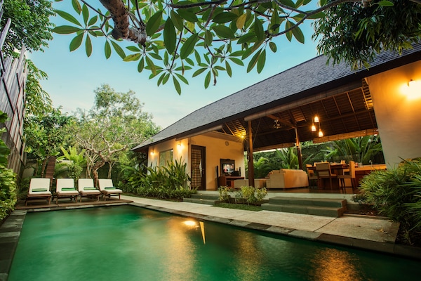 Una piscina al aire libre, sombrillas, tumbonas