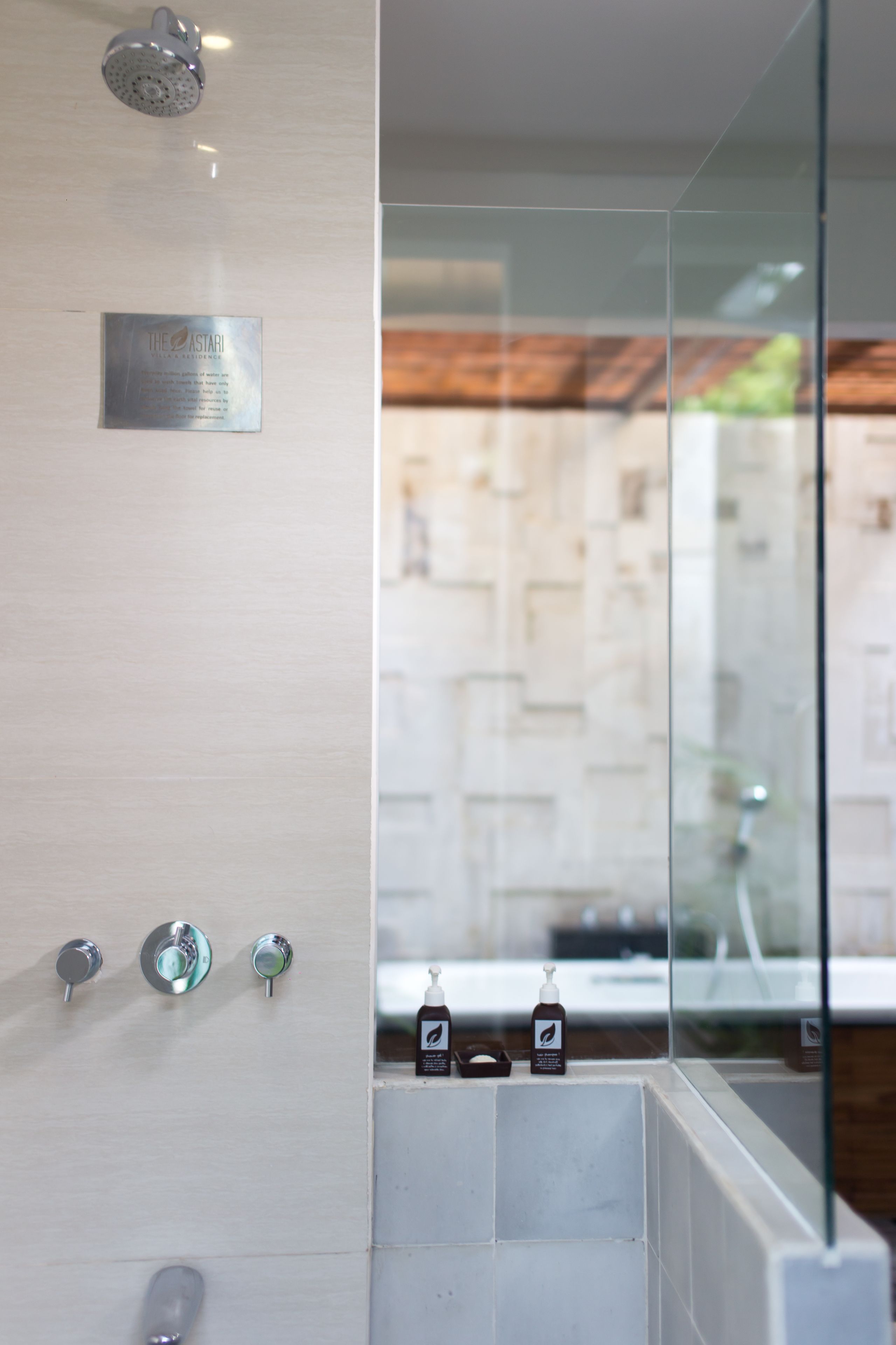 A modern bathroom with a glass partition, a showerhead, and a plaque.