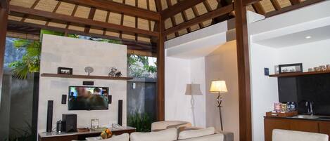 A modern living room with a TV, sofa, and dining table.