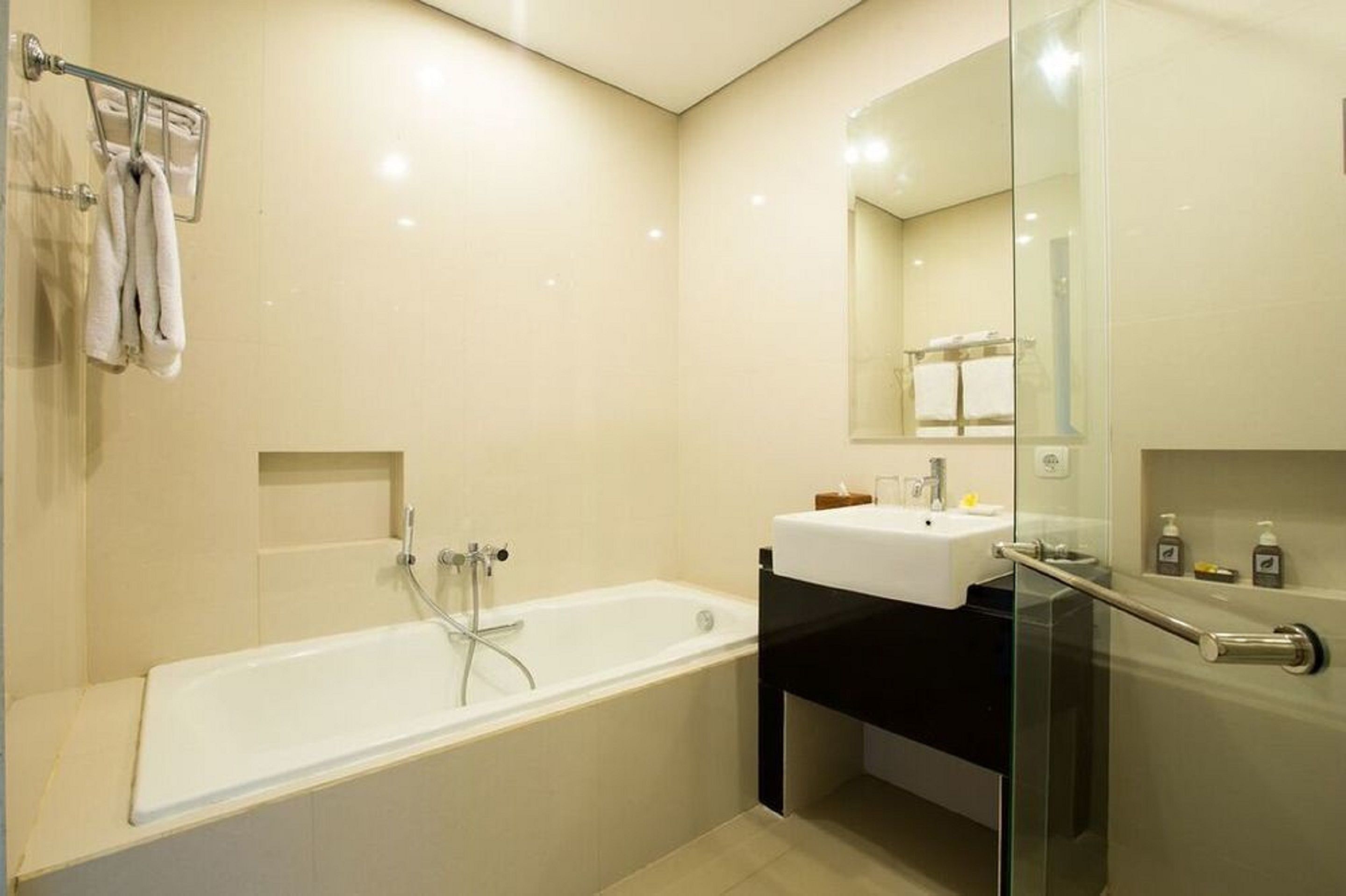 A modern bathroom with a bathtub, a sink, and a glass shower enclosure.