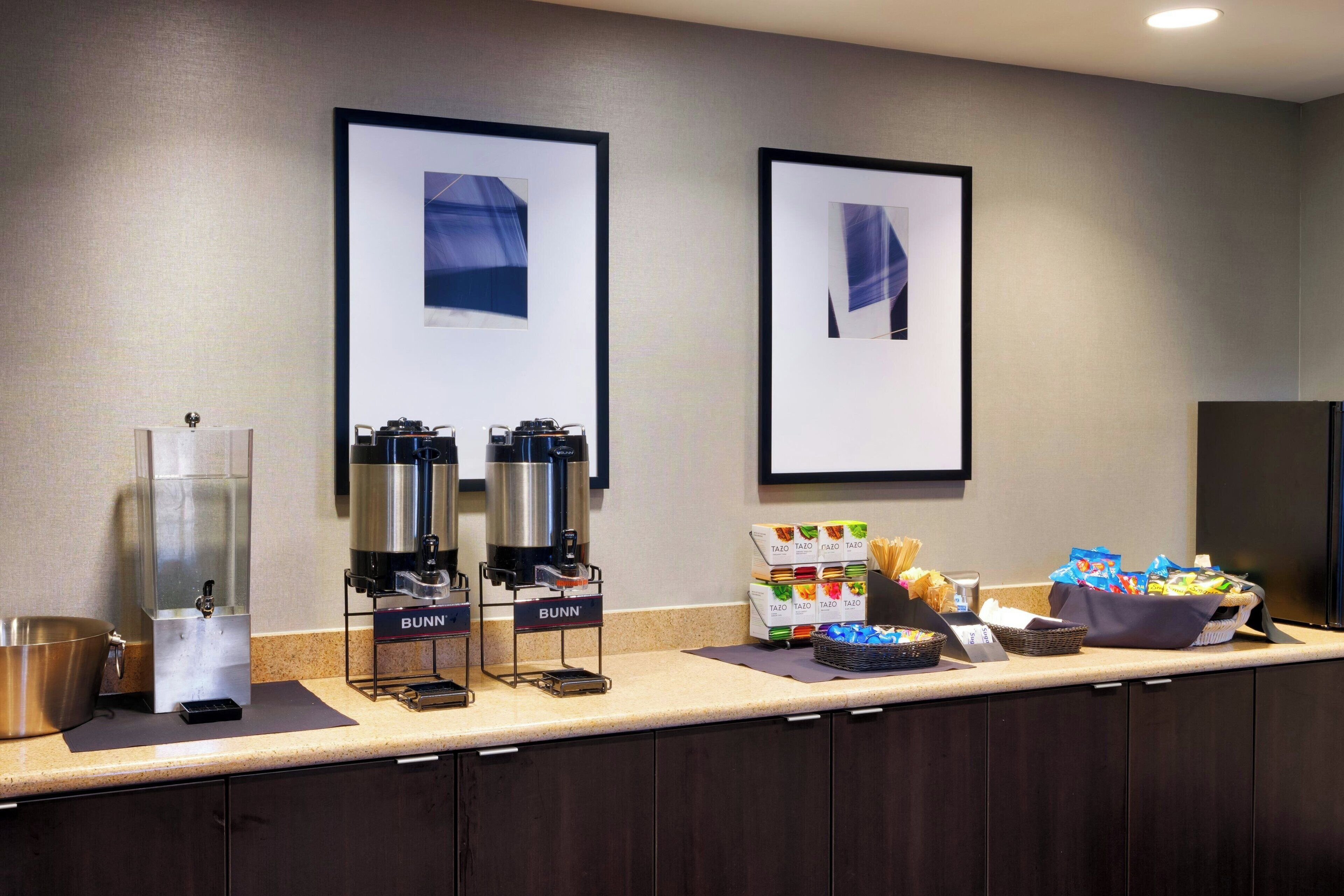 Et hotellets morgenmadsområde med kaffestation, frugtudstilling og snackbar.