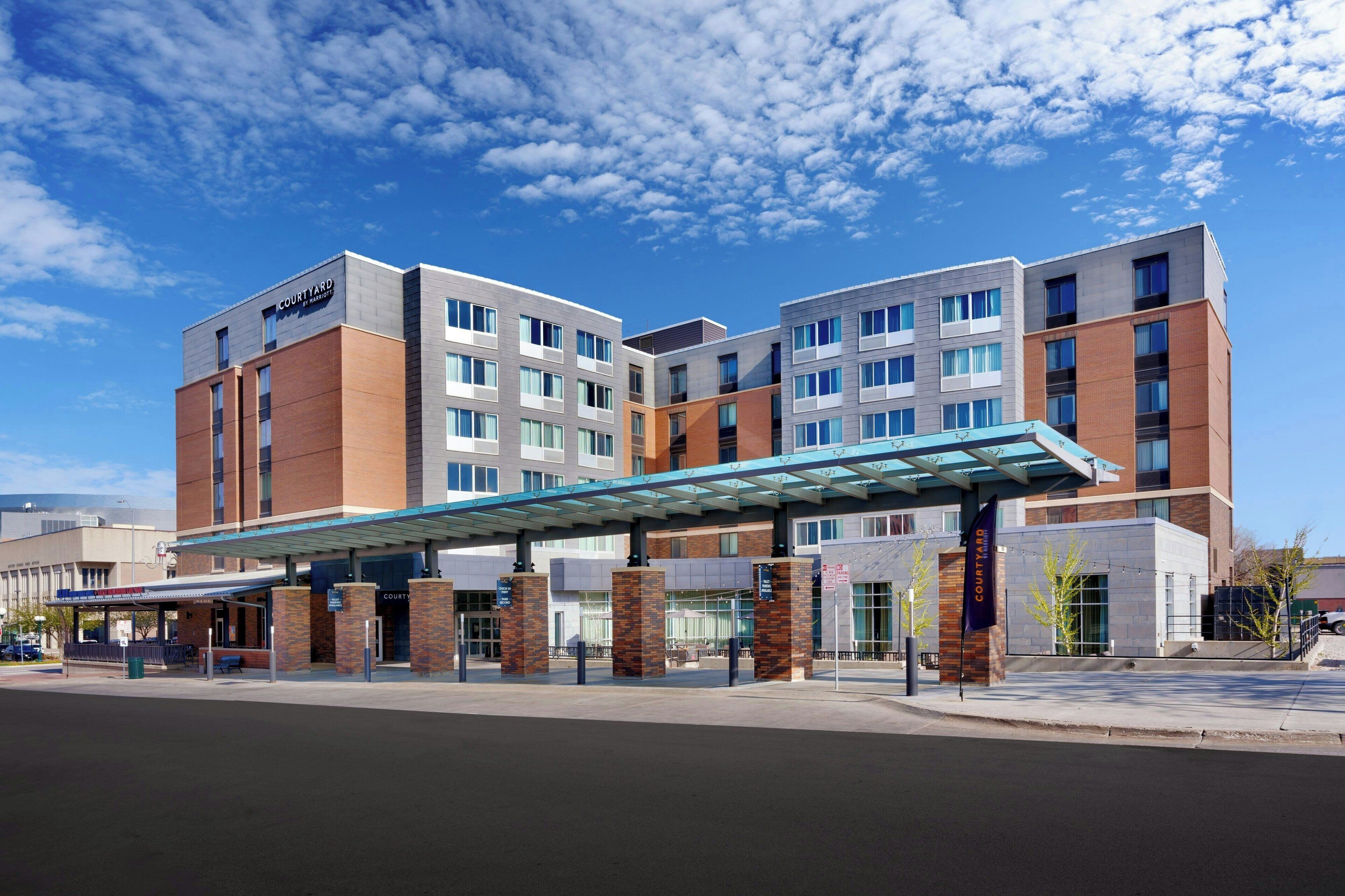 A Courtyard hotel with a modern design, featuring a covered entrance and multiple floors.