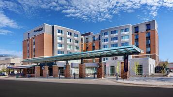 A Courtyard hotel with a modern design, featuring a covered entrance and multiple floors.