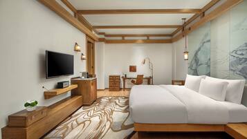 Un dormitorio moderno con cama, televisión, muebles de madera y escritorio.