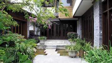 A traditional Japanese-style garden with a stone pathway leading to a wooden door.