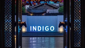 Entrada de hotel con un letrero que dice "INDIGO" y elementos arquitectónicos chinos tradicionales.