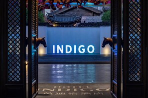 A hotel entrance with a sign reading "INDIGO" and traditional Chinese architectural elements.