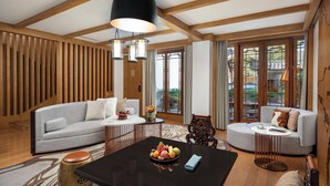 Una sala de estar moderna con un sofá gris, una mesa redonda de centro con fruta y un techo de madera.