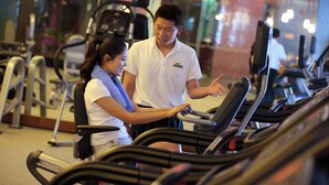Un gimnasio con cintas de correr y equipo de ejercicio.