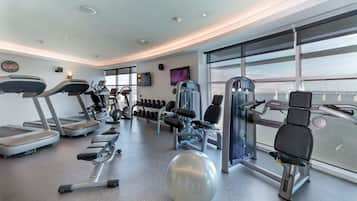 A modern gym with treadmills, elliptical machines, and weight equipment.