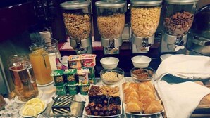 A buffet with various food items, including cereals, fruits, and pastries. - Art Rustic Hotel (Chisinau)