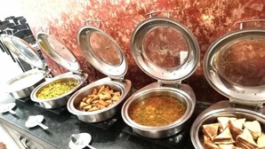 Een buffet met diverse gerechten en bestek.