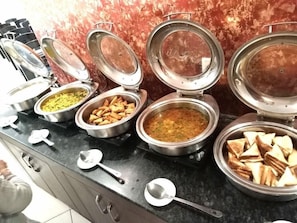 Montaje de bufé con diversos alimentos y utensilios.