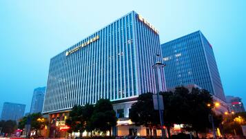 A modern hotel building with a prominent vertical design and reflective glass facade.