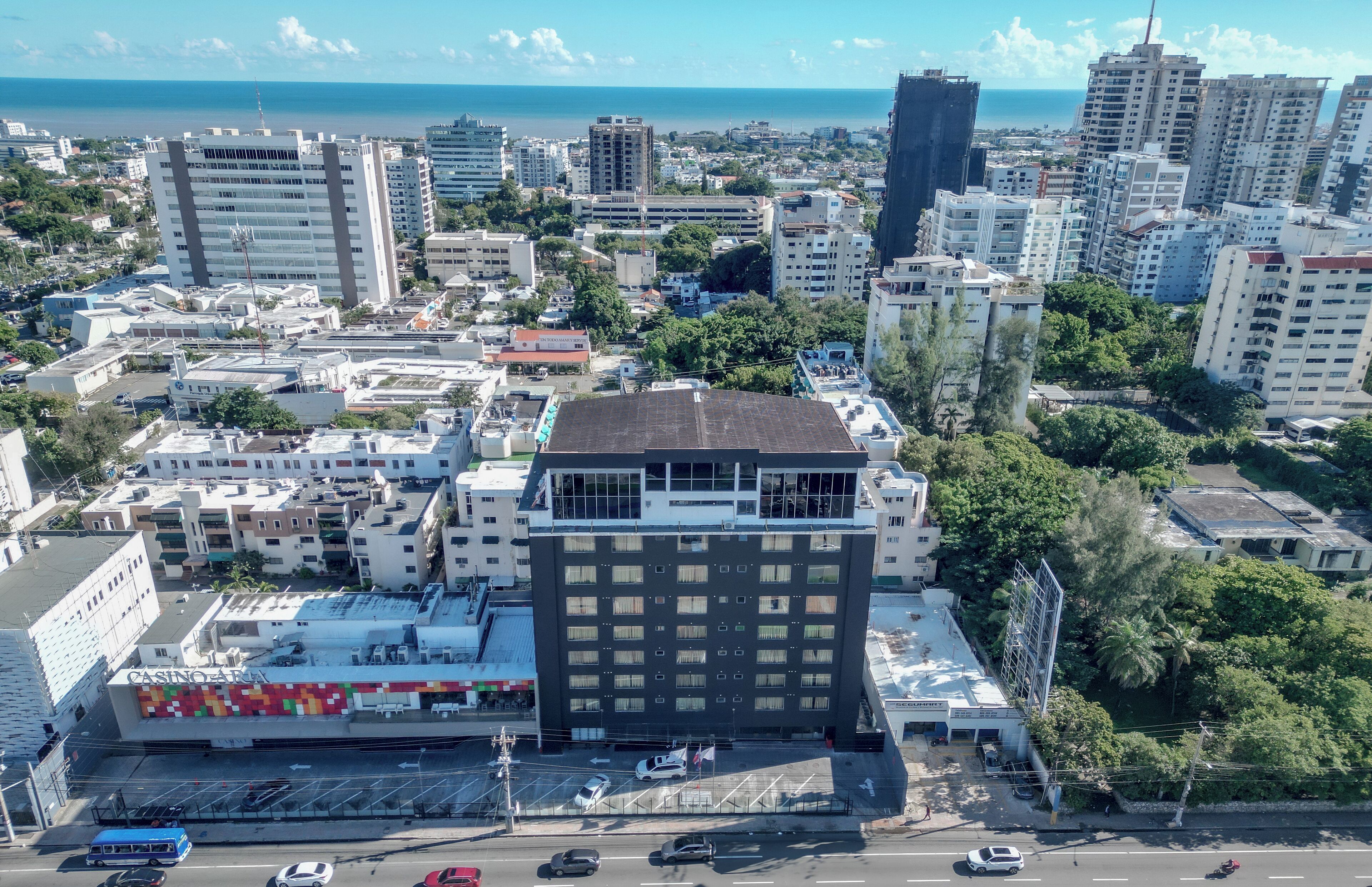Ein Hochhaus mit einem Casino im Erdgeschoss, umgeben von anderen Gebäuden und Blick auf das Meer.