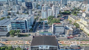 Un paisaje urbano con edificios modernos, una avenida central y un estacionamiento.
