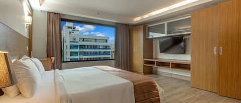Une chambre d’hôtel moderne avec un grand lit, une télévision et une vue sur un bâtiment situé à l’extérieur.