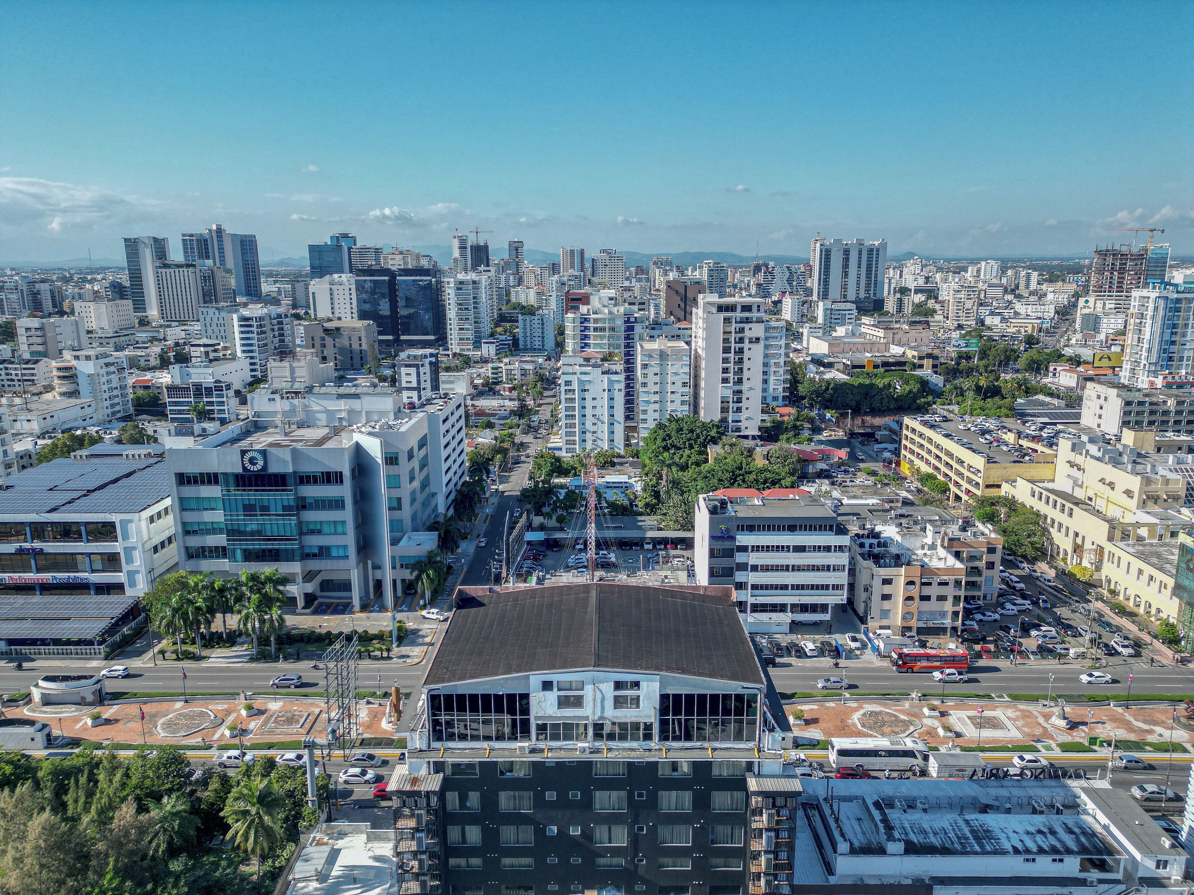 A cityscape with modern buildings, a prominent clock tower, and a mix of commercial and residential structures.