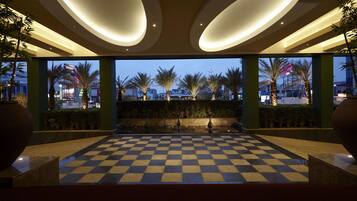 A checkered floor with a view of palm trees and buildings in the background.