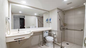 Een moderne badkamer met een witte wastafel, toilet en douchehoek.