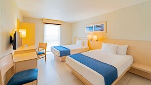 Habitación de hotel con dos camas, un escritorio, una silla y un televisor.