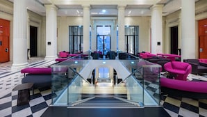 A lobby with a checkered floor, glass railings, and multiple seating areas with vibrant upholstery. - Radisson Blu Hotel Nantes (Nantes)