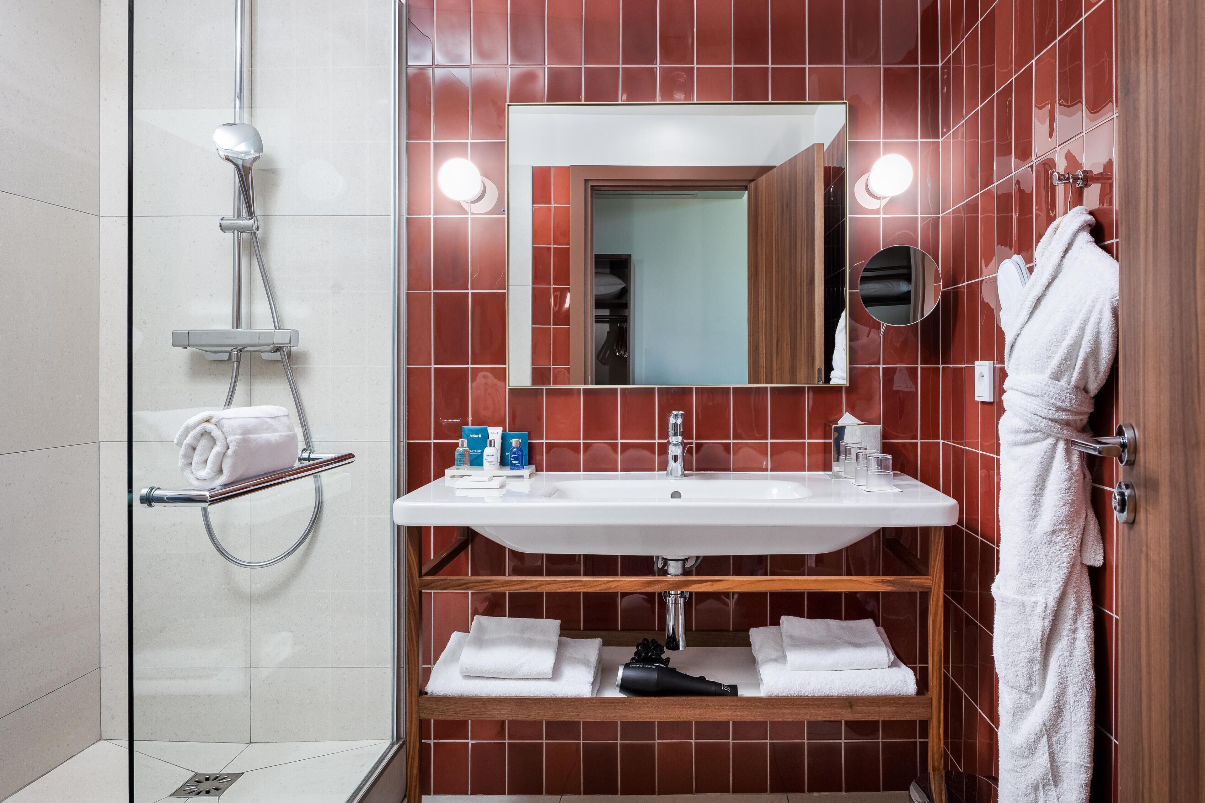 Ein Badezimmer mit Dusche, Waschbecken und Spiegel.