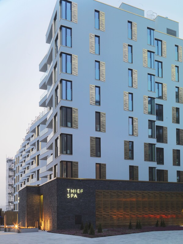 A modern multi-story building with a spa named "THIEF SPA" at the base.
