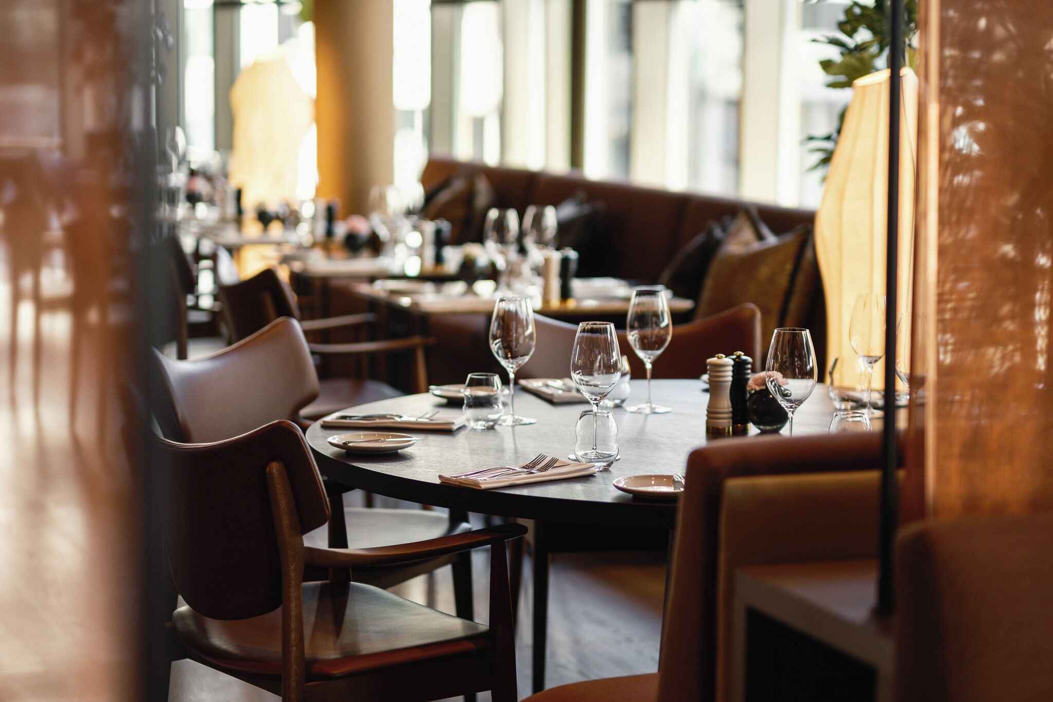 A restaurant with tables set for dining, chairs, and a warm ambiance.