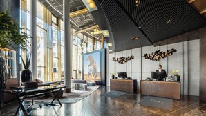 A modern reception area with a large desk, seating, and a mural.