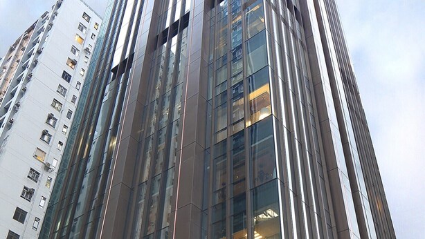 A tall, modern building with a glass facade and the name "Mira Moon" on the lower level.