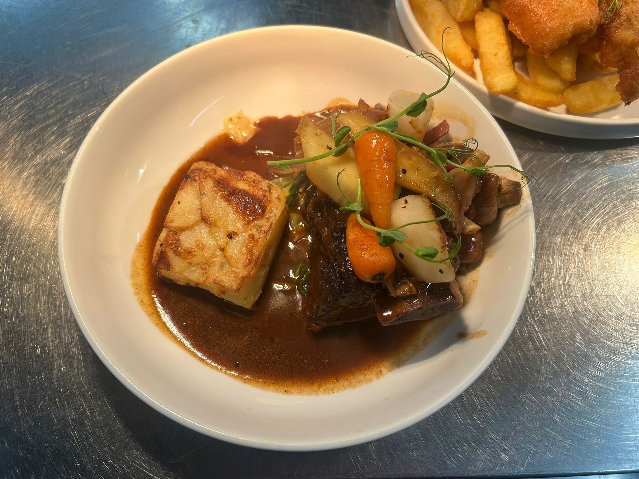 Um prato de comida com carne, legumes e molho.