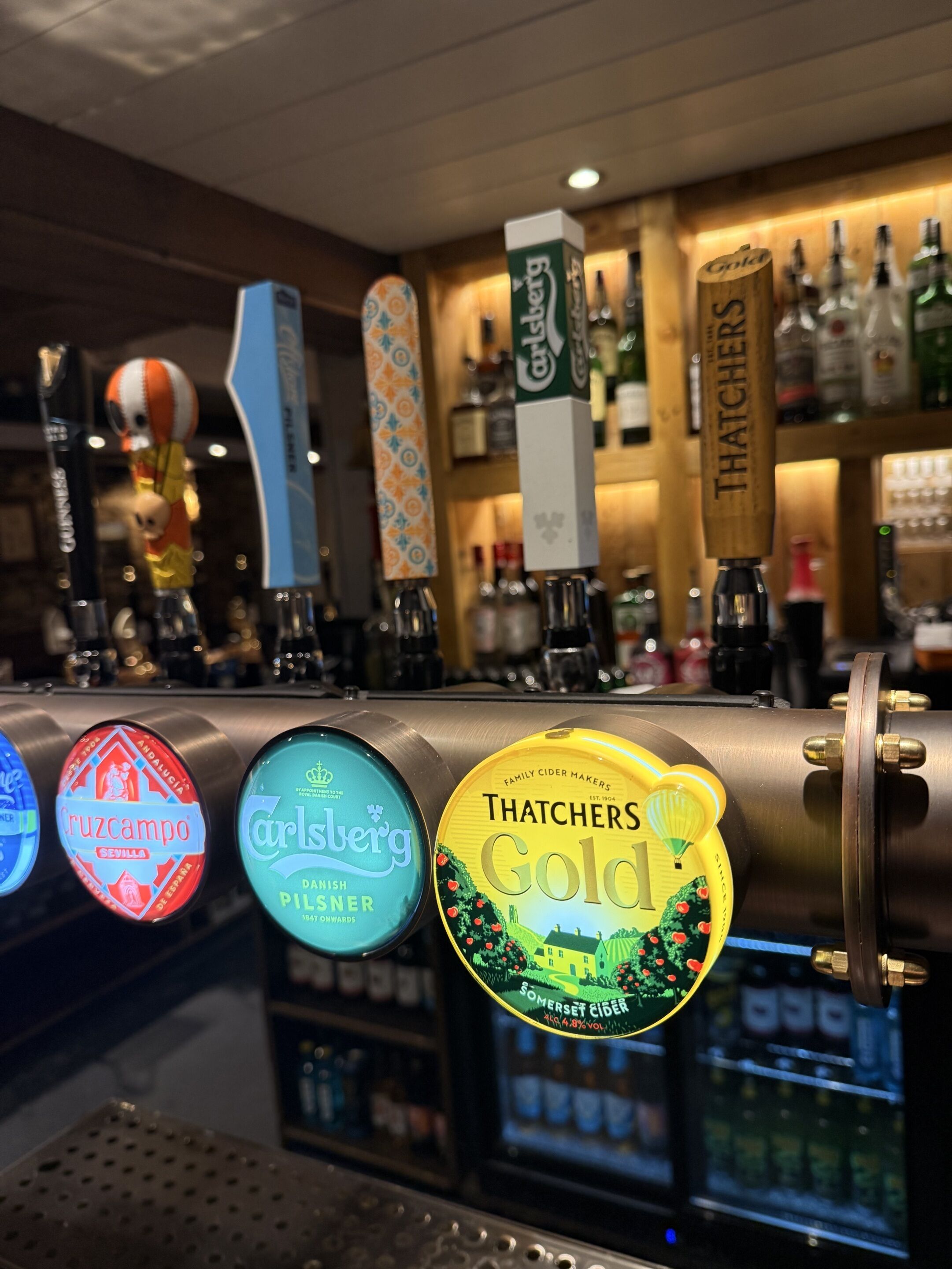 A bar with taps labeled with different beer brands.